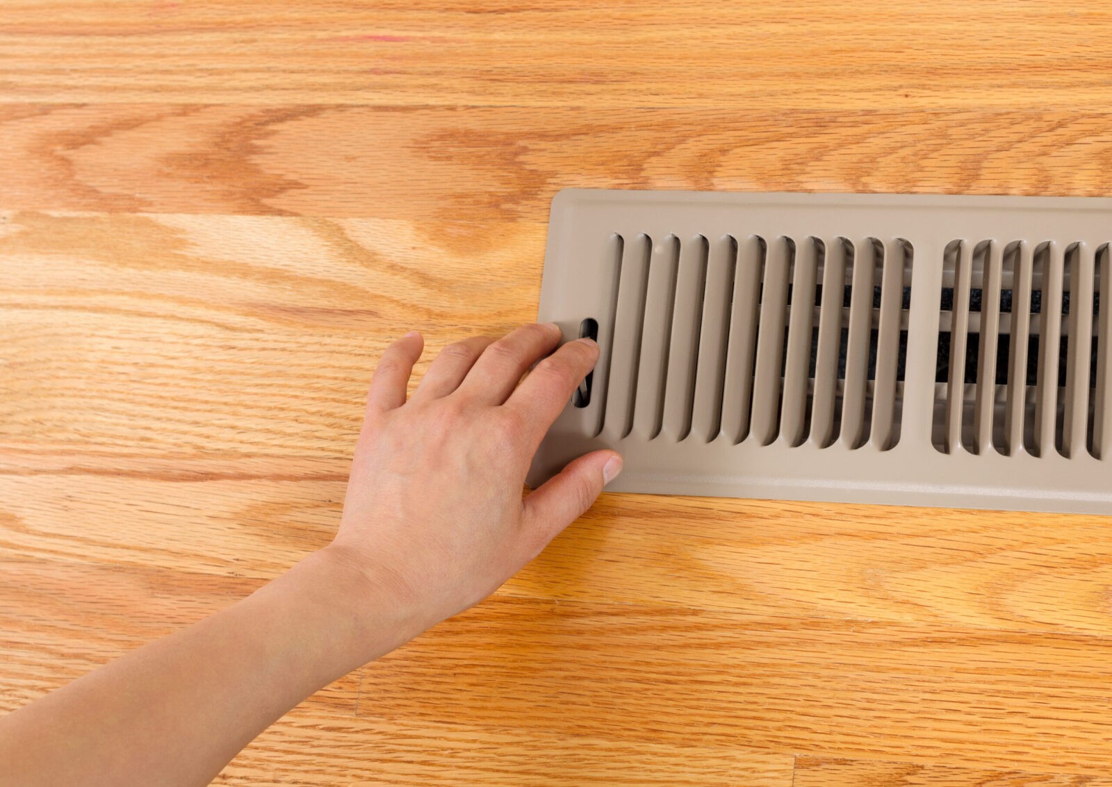 A homeowner closing a HVAC register