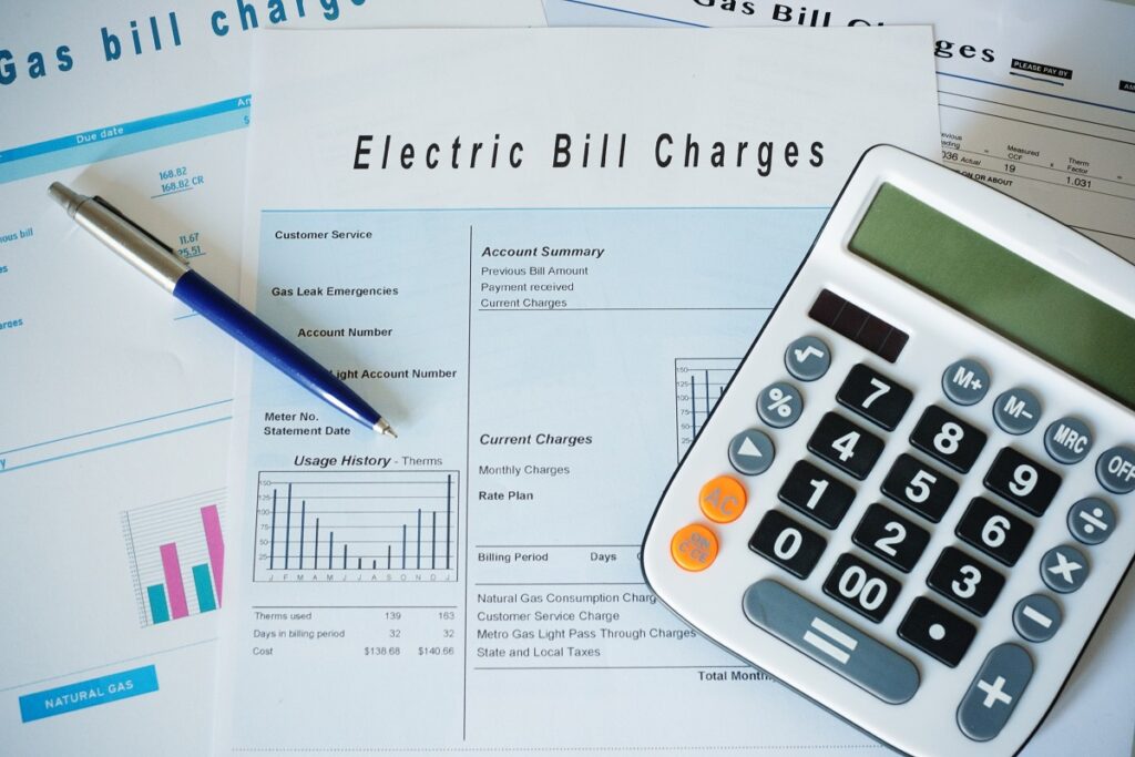 utility bills, a pen, and a calculator