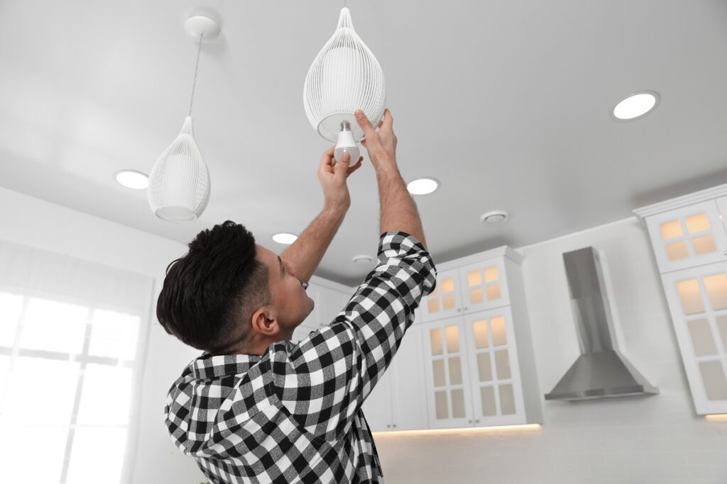 a homeowner changing a light bulb