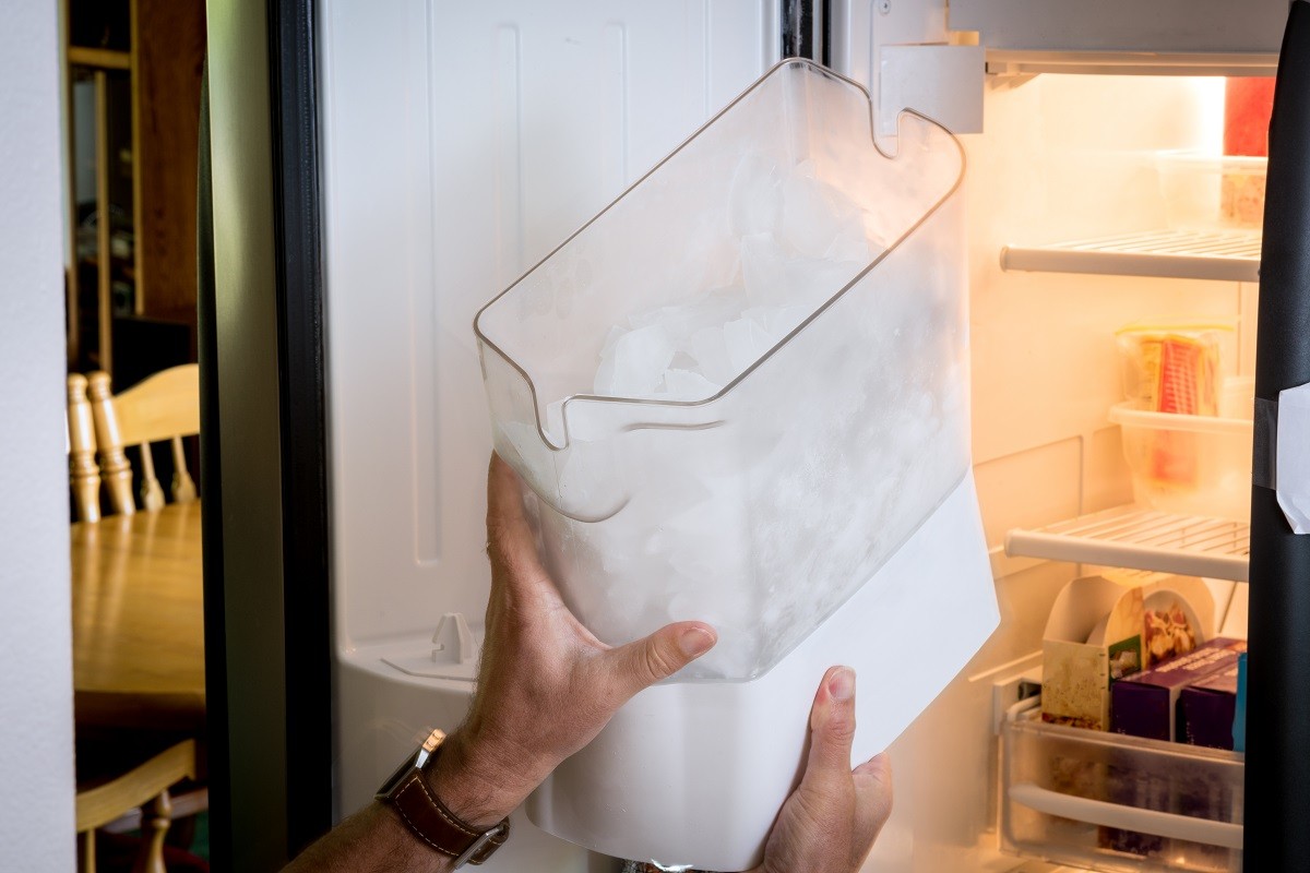 a homeowner holding a filled ice maker container