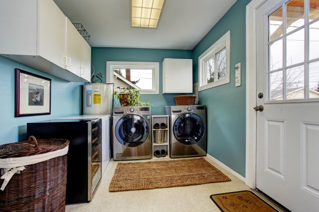 a blue-painted utility room with a washer, dryer, and hot water heater