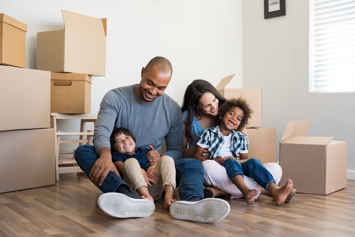 a family sitting in living room surrounded by moving boxes - packing tips
