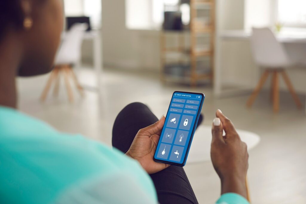 a homeowner holding a phone with a smart home app up