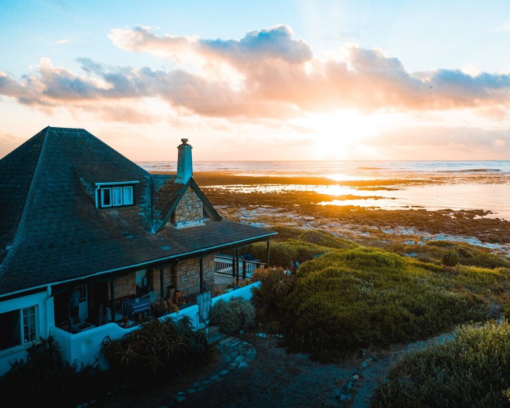 the sun is up and bright over a large cottage home