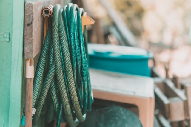 a garden hose hung up on the side of a hose