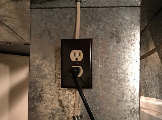 an outlet on the side of a humidifier that's plugged in