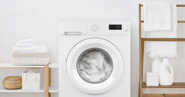 a front-loading washing machine has white towels being cleaned inside its basin