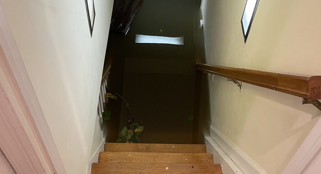 flood waters in a basement covering the stairs