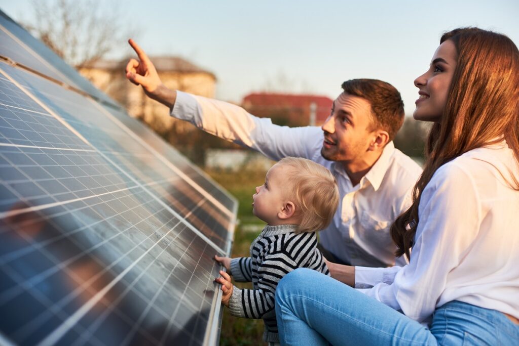 Young family looking at solar panels 