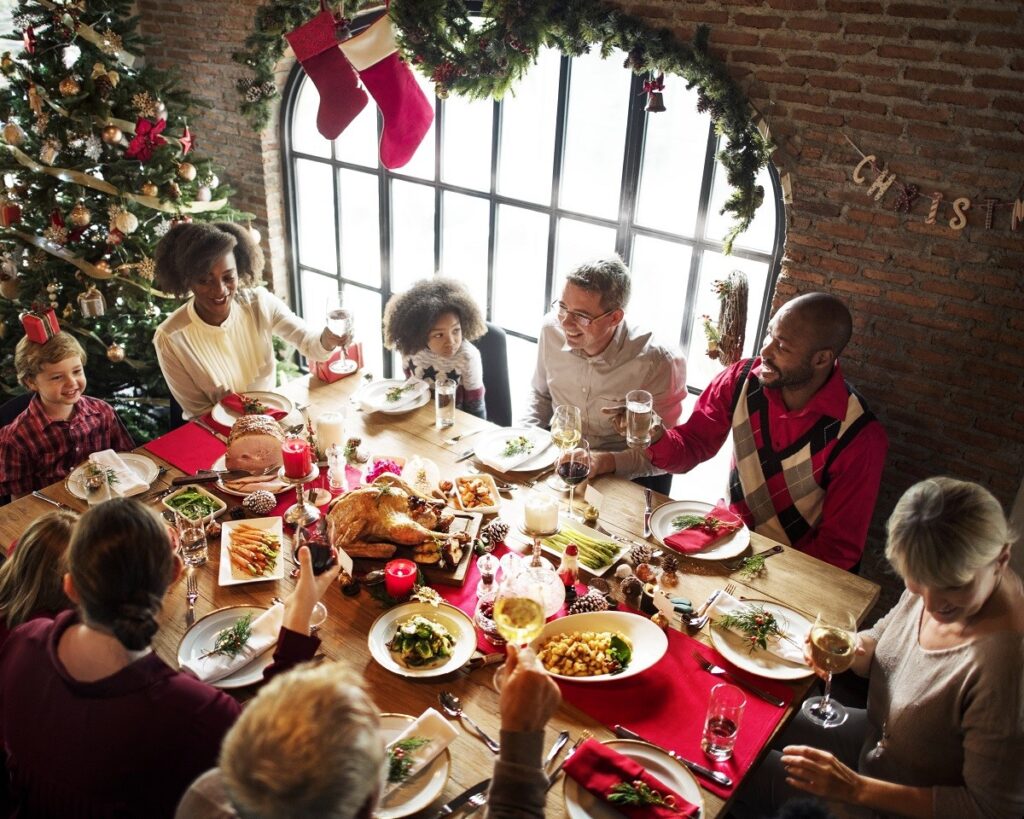 Family gathered around the holiday table making a toast