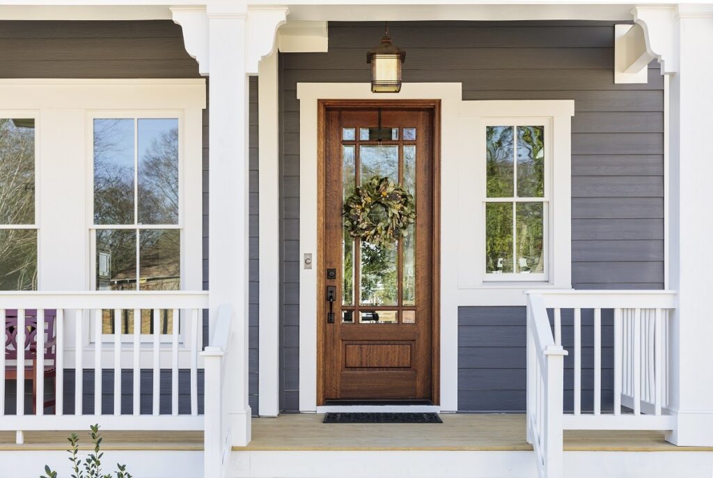 front porch with a wooden door with a wreath hanging on it