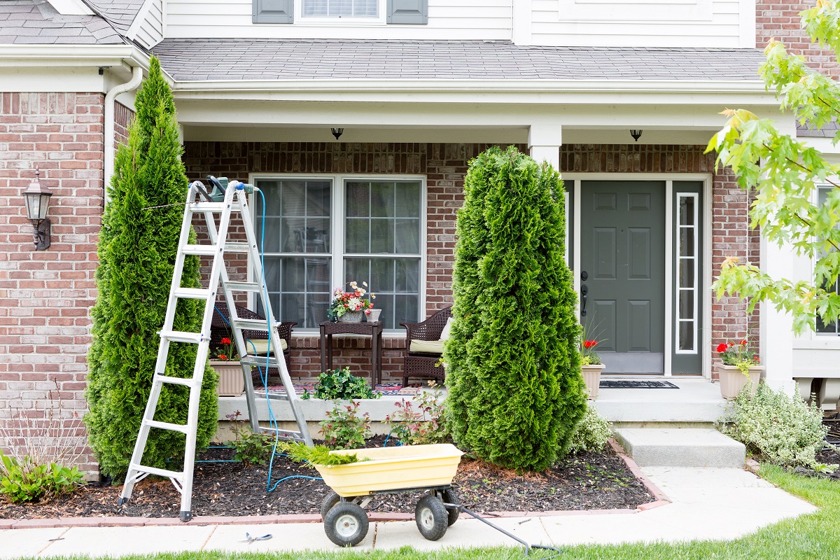 a ladder and a wheelbarrow outside of a home