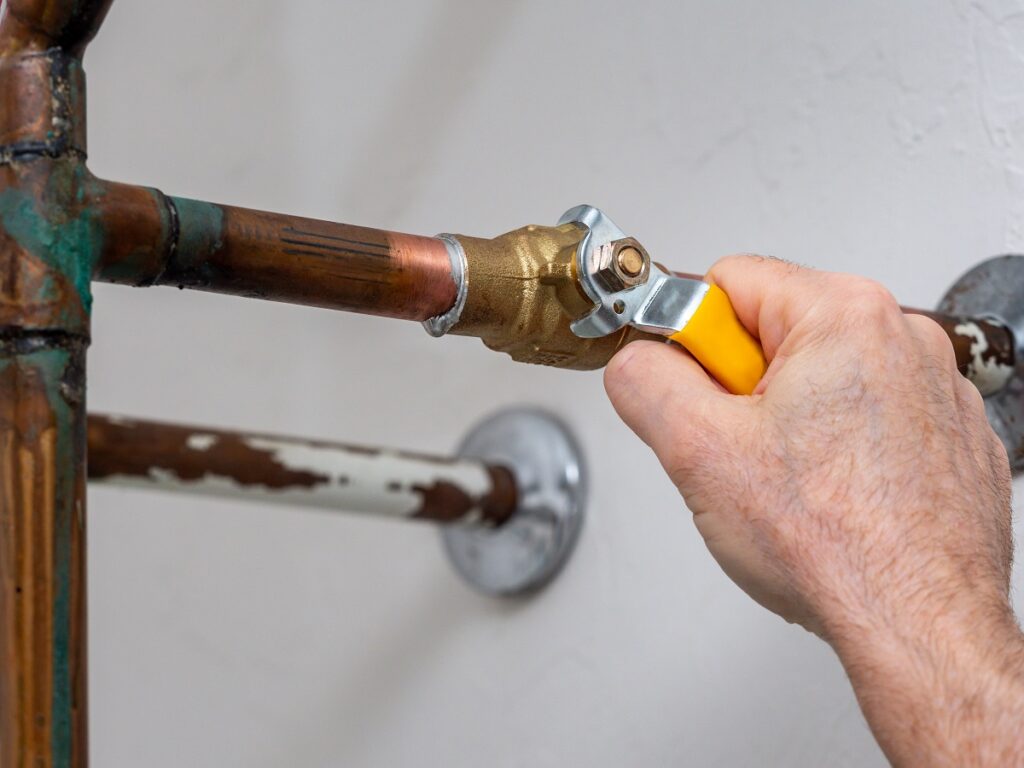 Plumber turning water shut off valve
